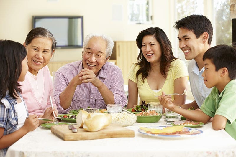 an image of a family all sitting around the dinner table with their older father discussing end of life care