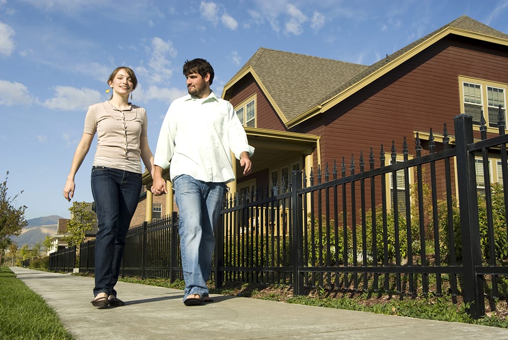 an image of a young man and woman walking together on a residential sidewalk