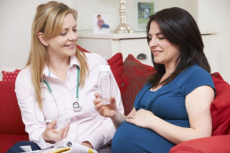 an image of a woman receiving prenatal care from a female doctor